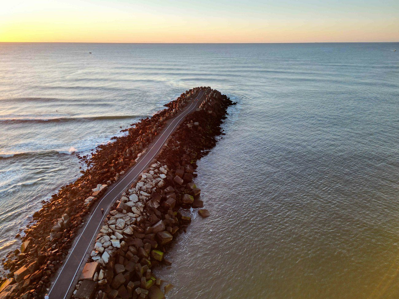 A rocky breakwater extending into calm water at Ballina