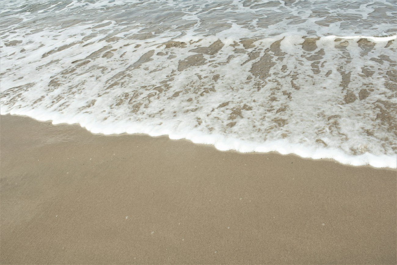 Foamy surf washing onto sand at Coffs Harbour
