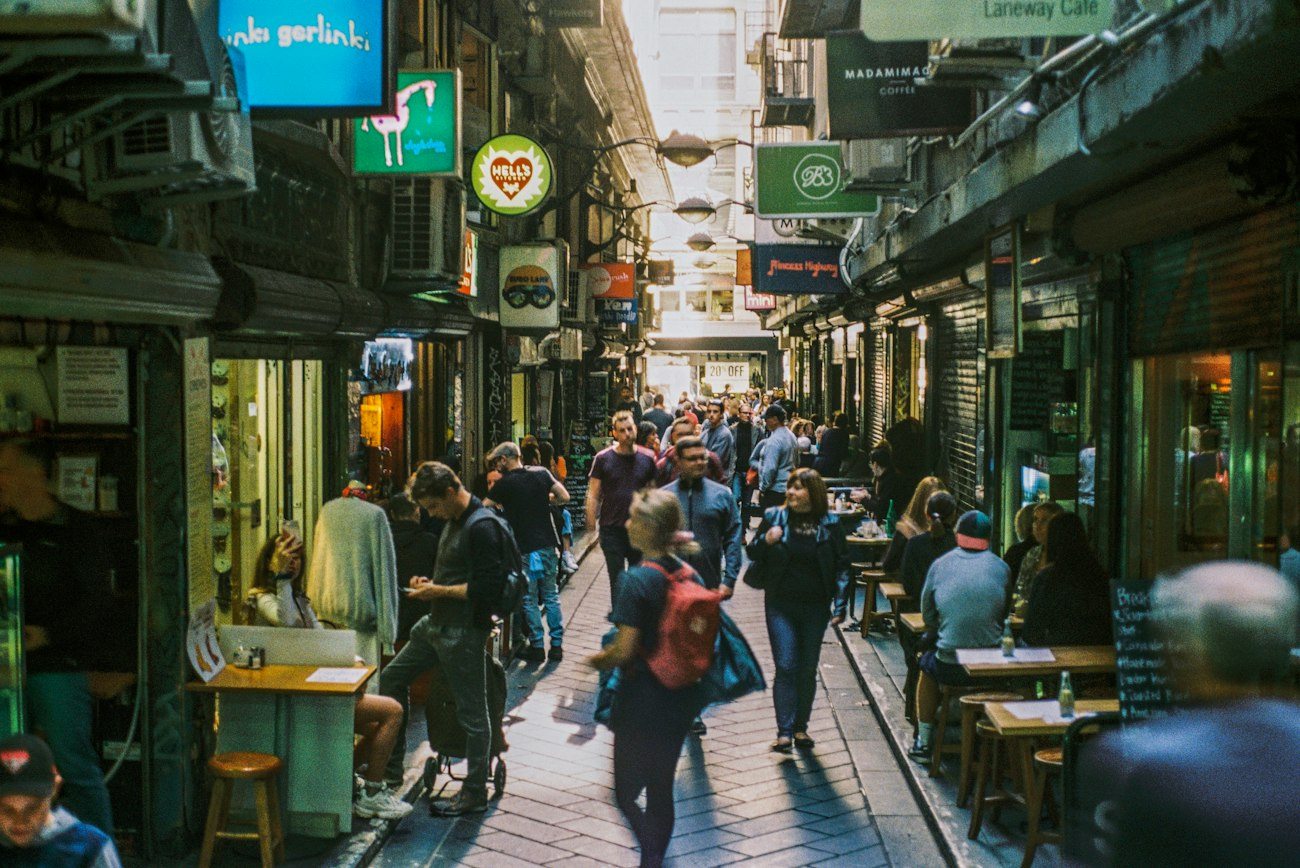 Cafe tables and pedestrians in a busy Melbourne laneway
