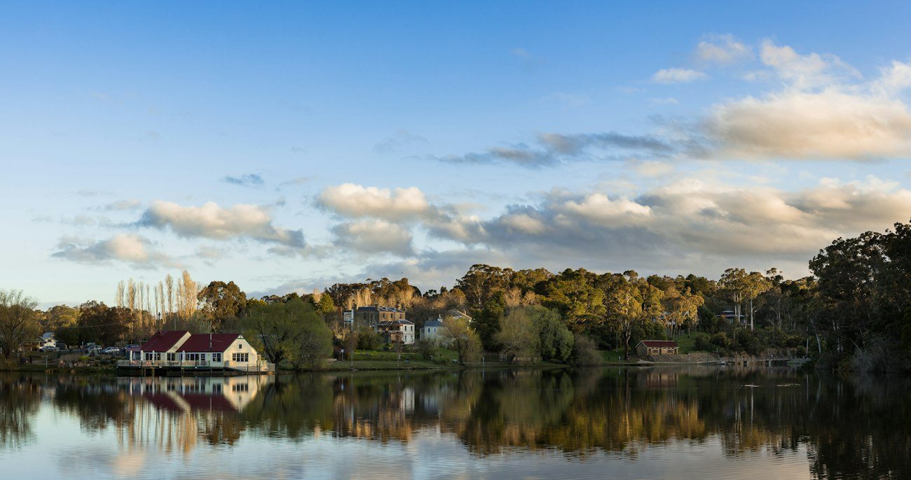 Trees and lakeside buildings reflected in Lake Daylesford