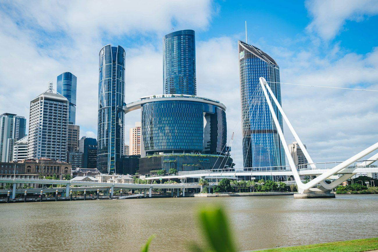 Brisbane towers and a pedestrian bridge beside the river