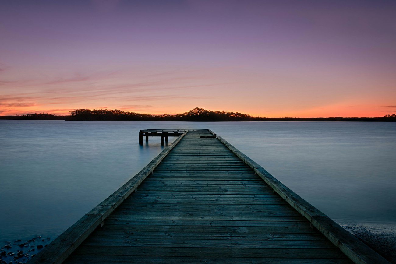 A wooden jetty extending into still water near Strahan