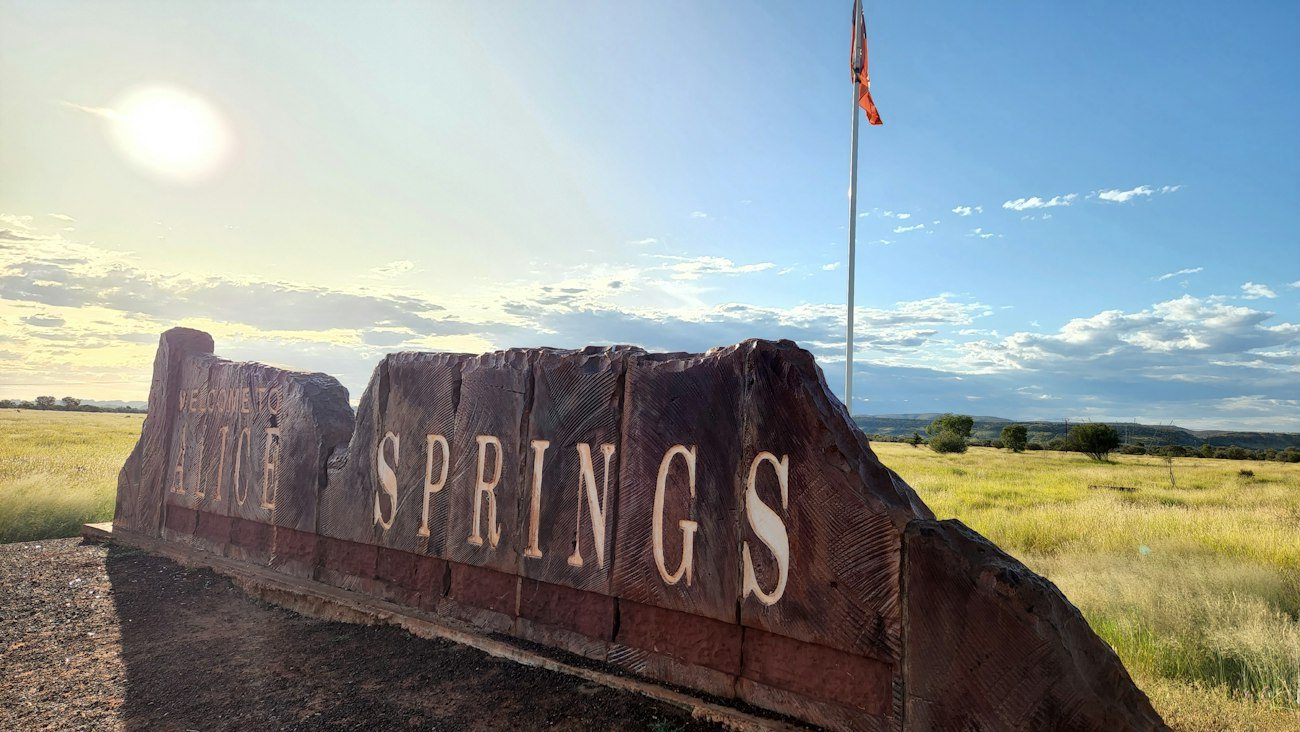 The Alice Springs town sign beside an open road