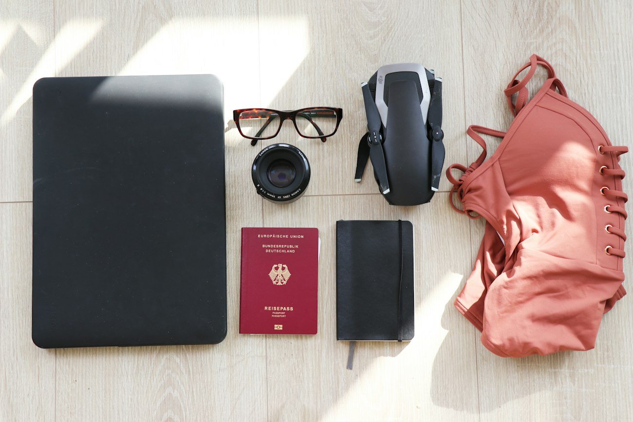 A laptop, passport and travel equipment laid out on a table