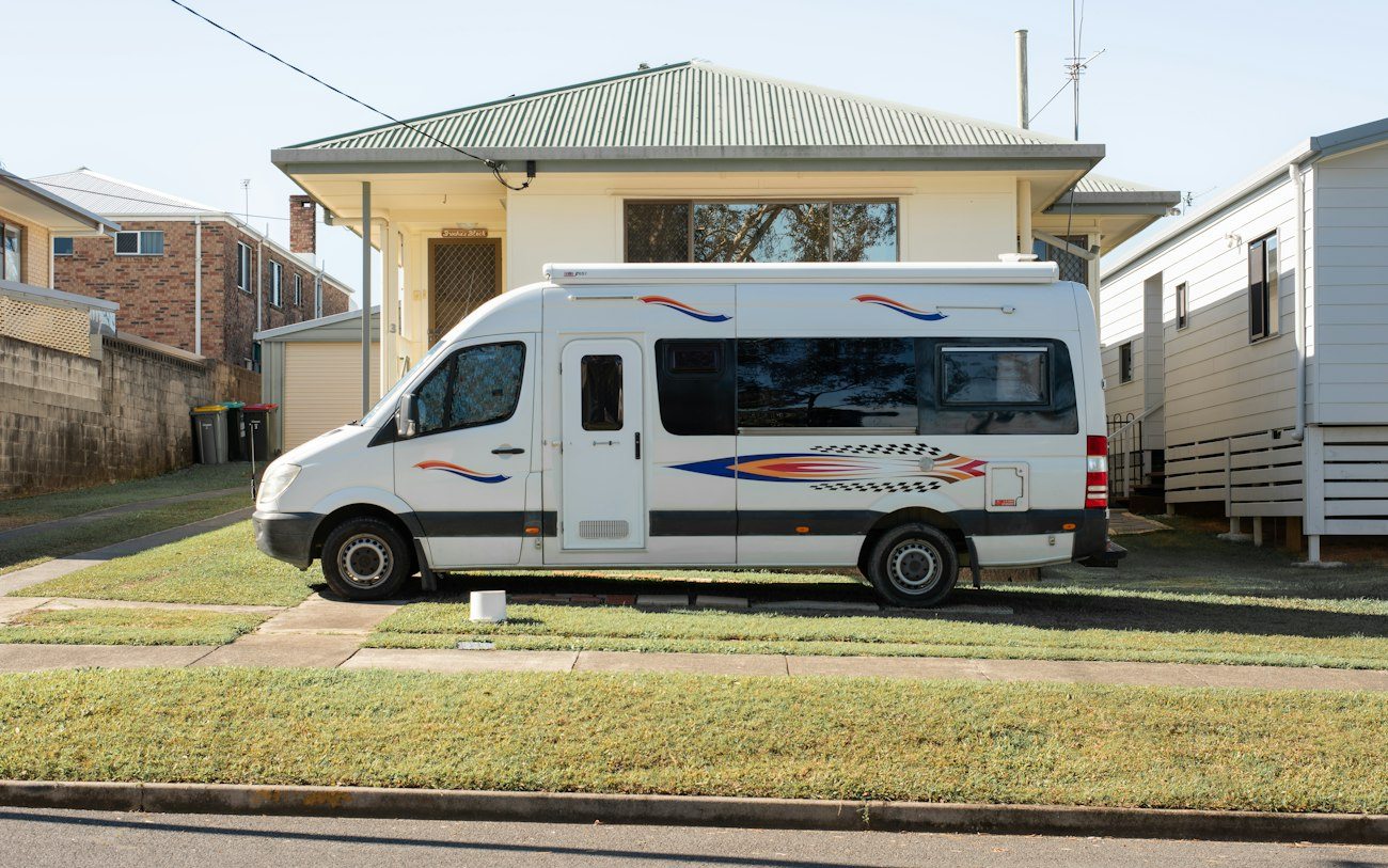A campervan parked beside a house