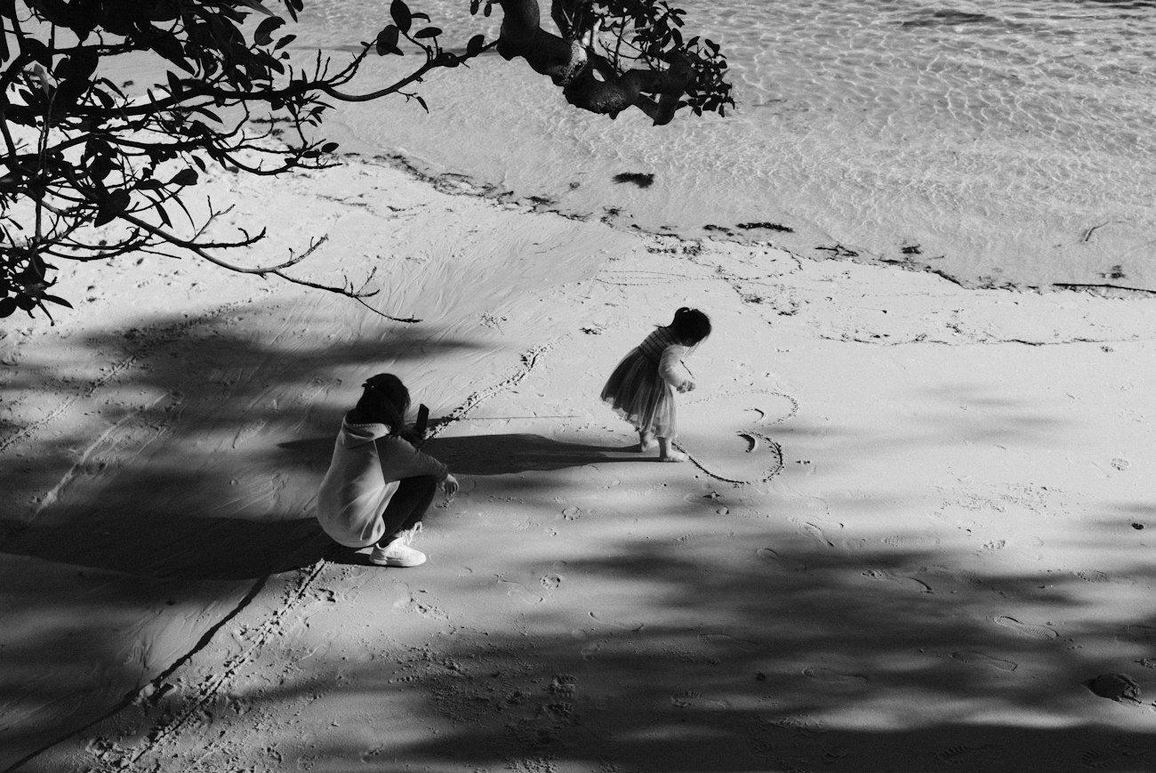 Children playing in the sand beside the water at Watsons Bay