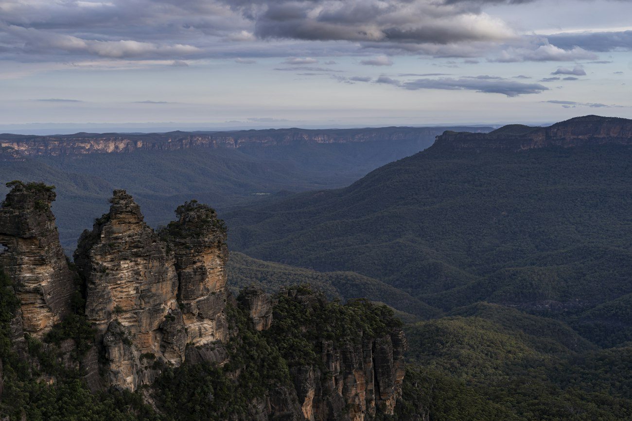 The Three Sisters above a forested Blue Mountains valley
